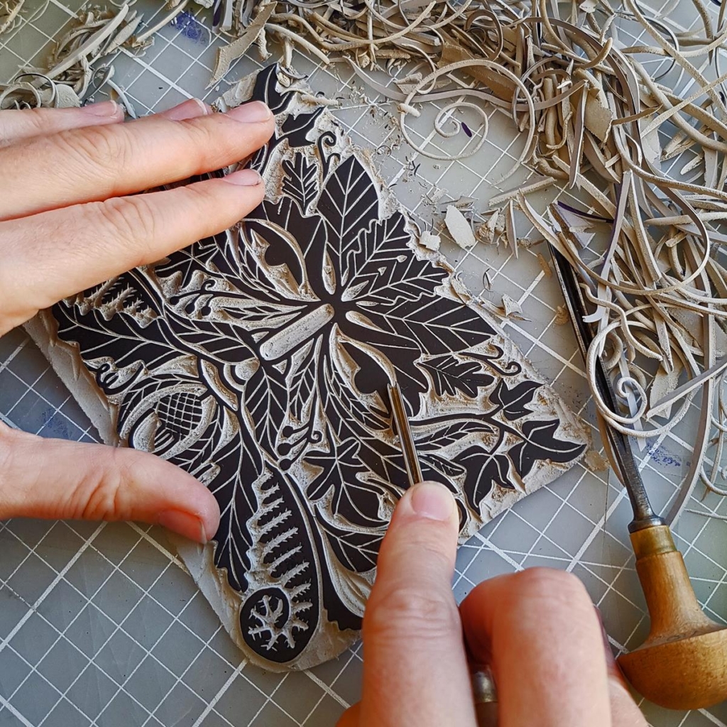 Becca Thorne working on cutting a lino print