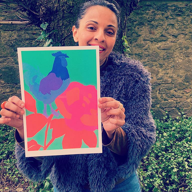 Mahin Hussain holding brightly coloured rooster artwork