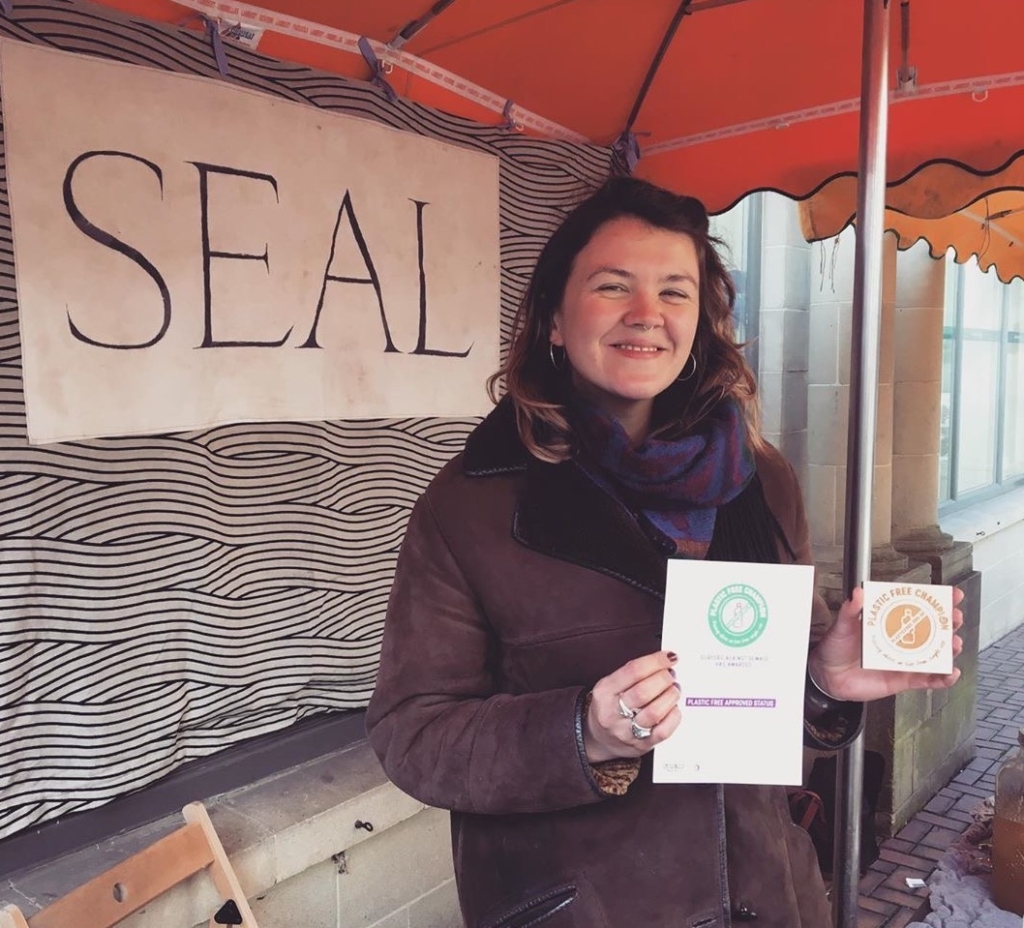 Meghan of Seal brand natural toiletries at her market stall holding a certificate