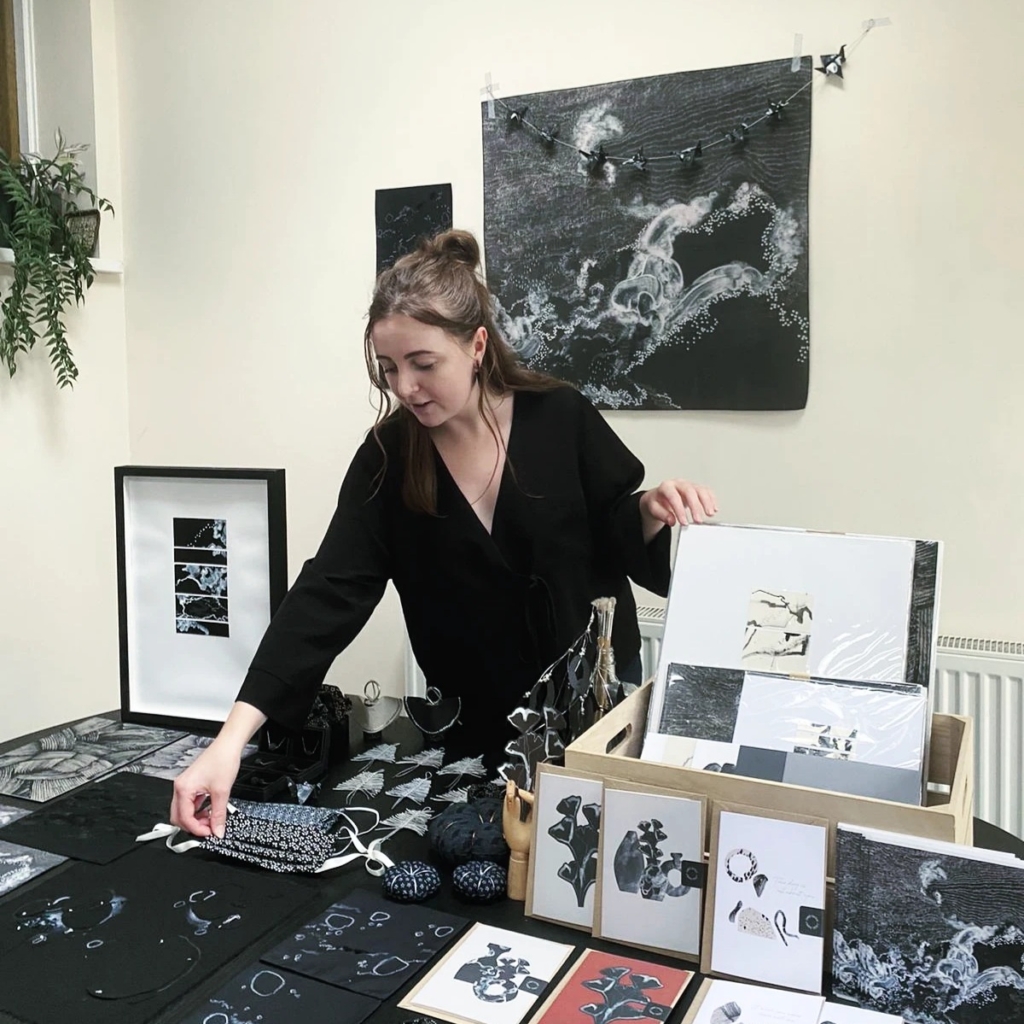Ellie Mawby setting out her monochrome artwork on craft stand