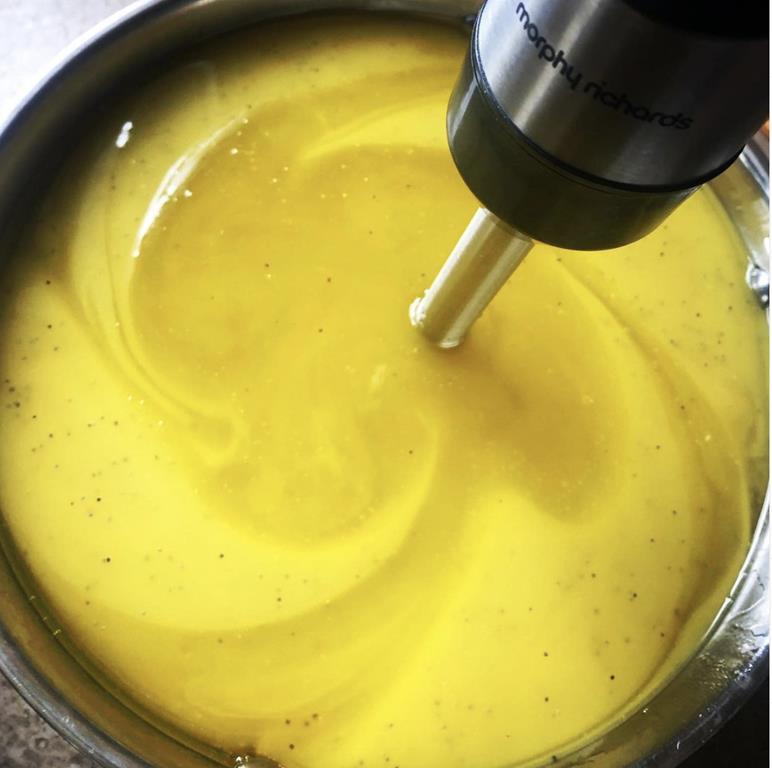 yellow hand made cold process soap being whisked with electric whisk