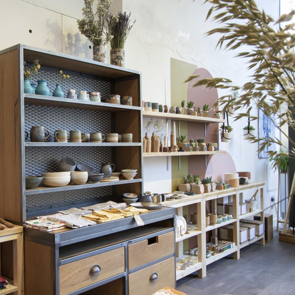 Prior shop, Bristol, showing display shelving with attractive ceramic tableware and plant pots.
