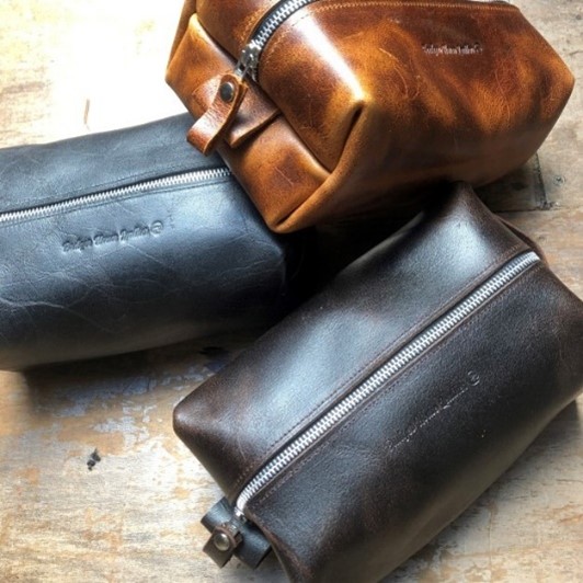 Three zipped leather wash bag pouches in tan, dark brown and black, by Badger House Leather.