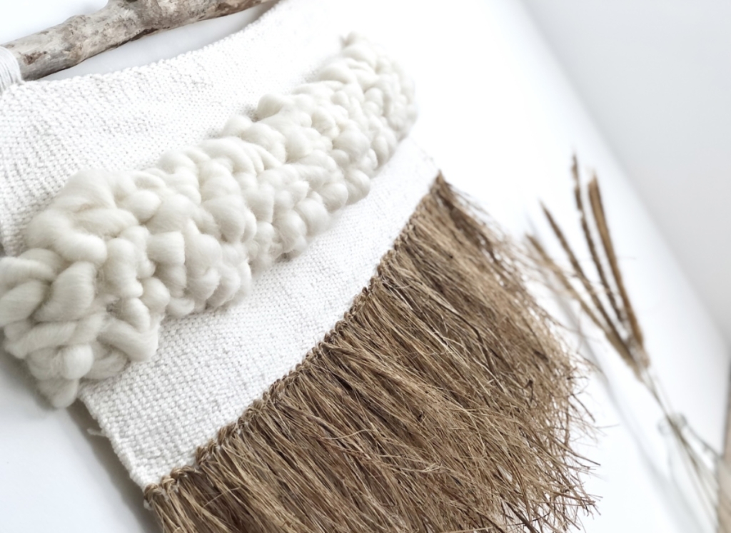 Handwoven wall hanging with chunky white detailing and brown tassels, hung on driftwood, by Weave Love Amy.