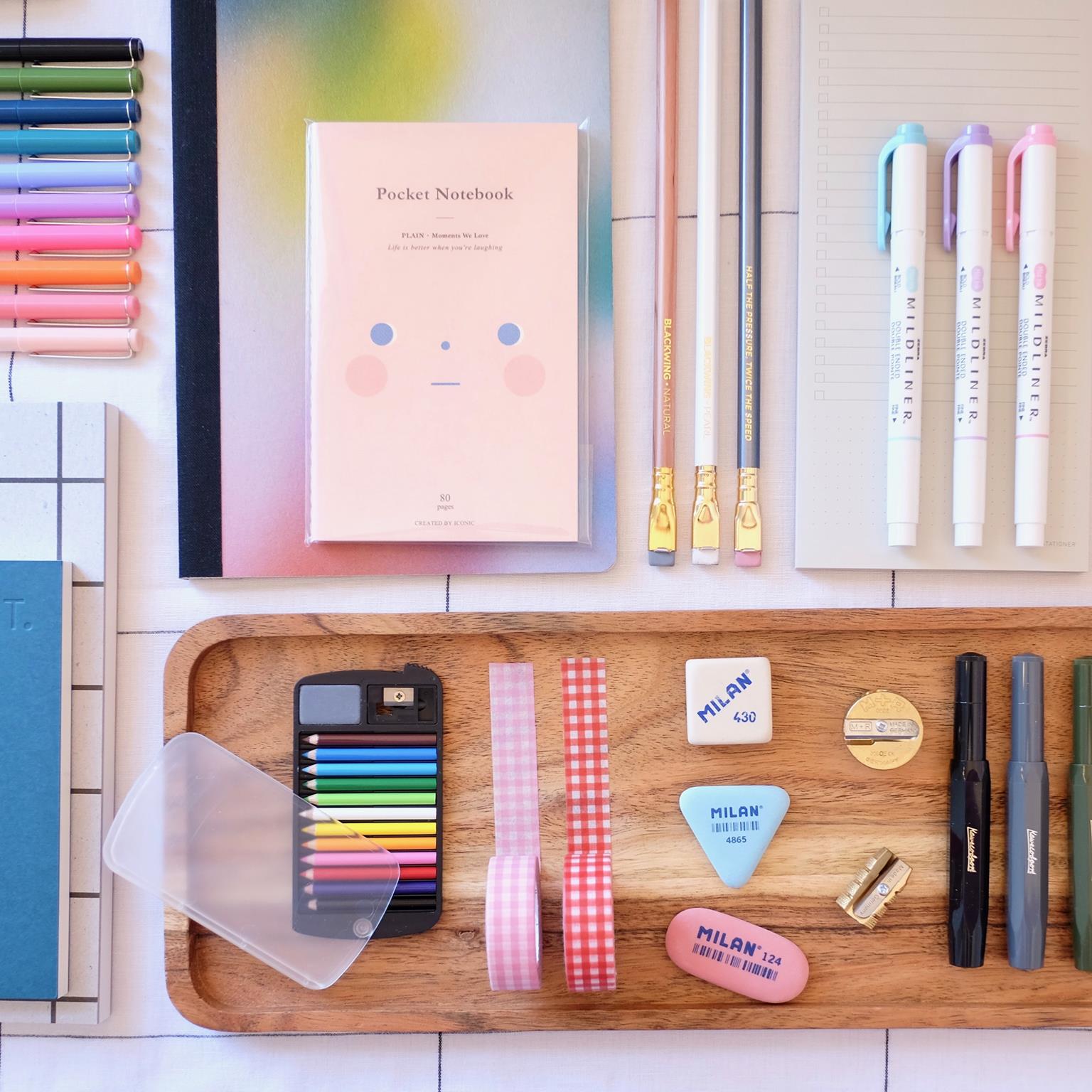 assorted brightly coloured stationery items, arranged attractively. By The Stationer.