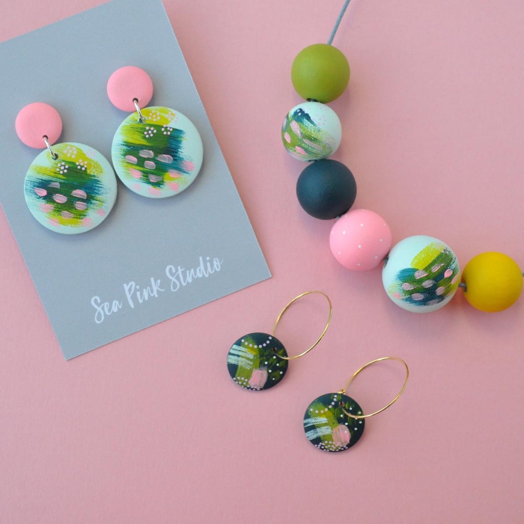 Set of brightly painted wooden jewellery titled 'Gylly Abstract Set' in shades of green, yellow, pink and dark blue, by Sea Pink Studio.