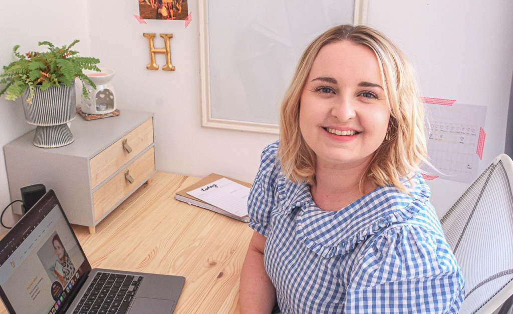 Hannah Isted of HI Communications at her desk, smiling up at the camera.