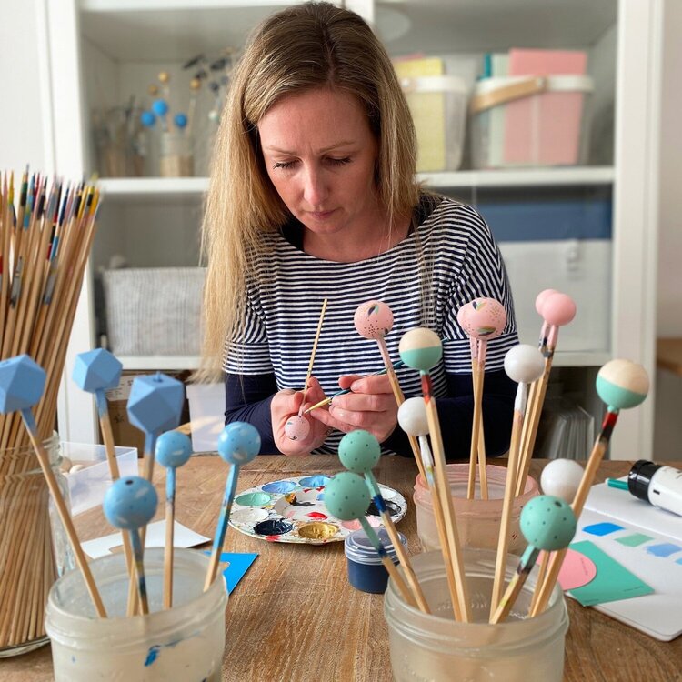 Sally of Sea Pink Studio painting Large round wooden beads in bright beach and ice cream shades. Made of sustainable wood, by Sea Pink Studio.
