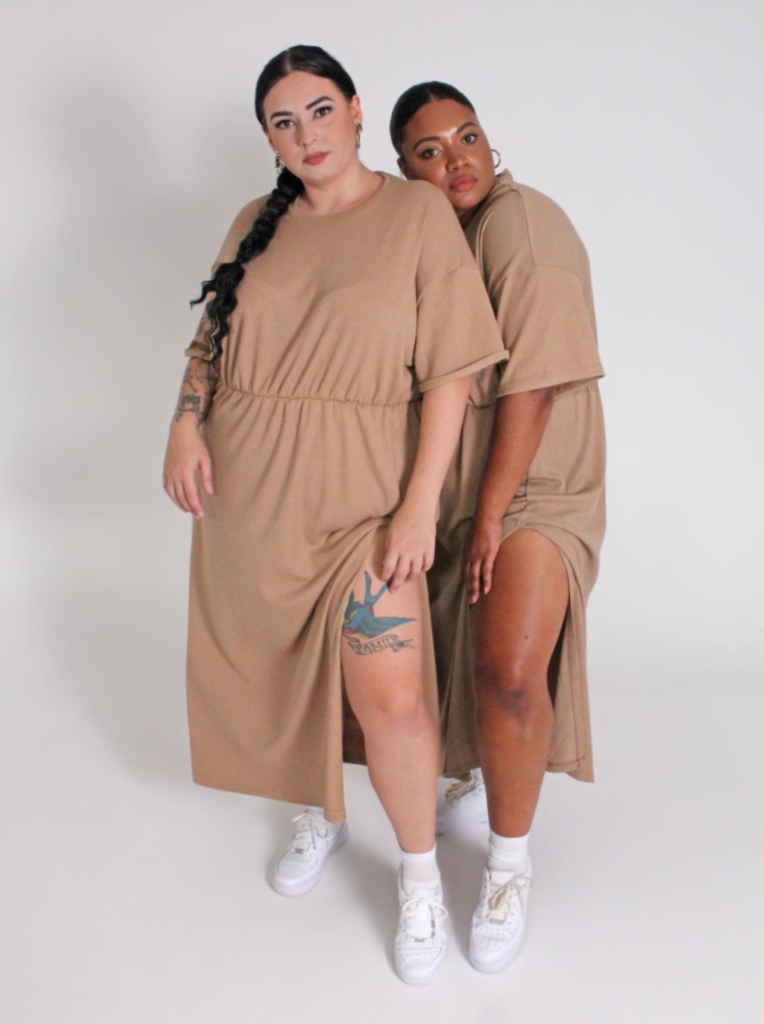two models wearing loose jersey dresses in tan, with gathered waist, by Adina Monette