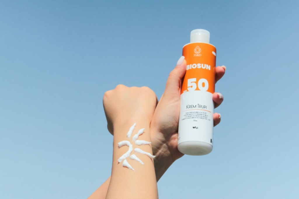 hands holding up a bottle of sunscreen