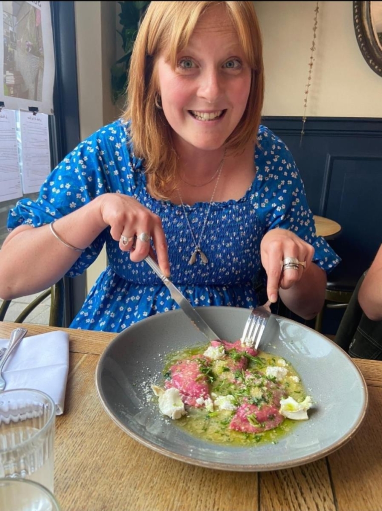 Sian Rosier smiling and eating in a restaurant