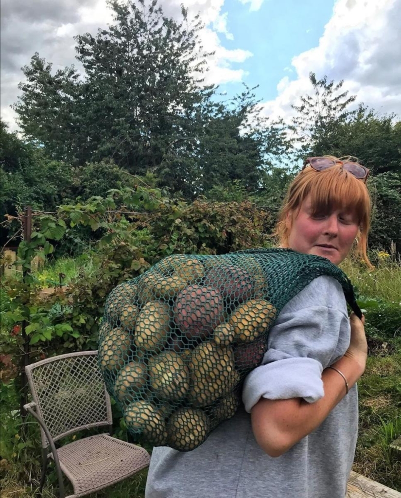 Sian Rosier carrying a large bag of farm potatoes in a string bag.