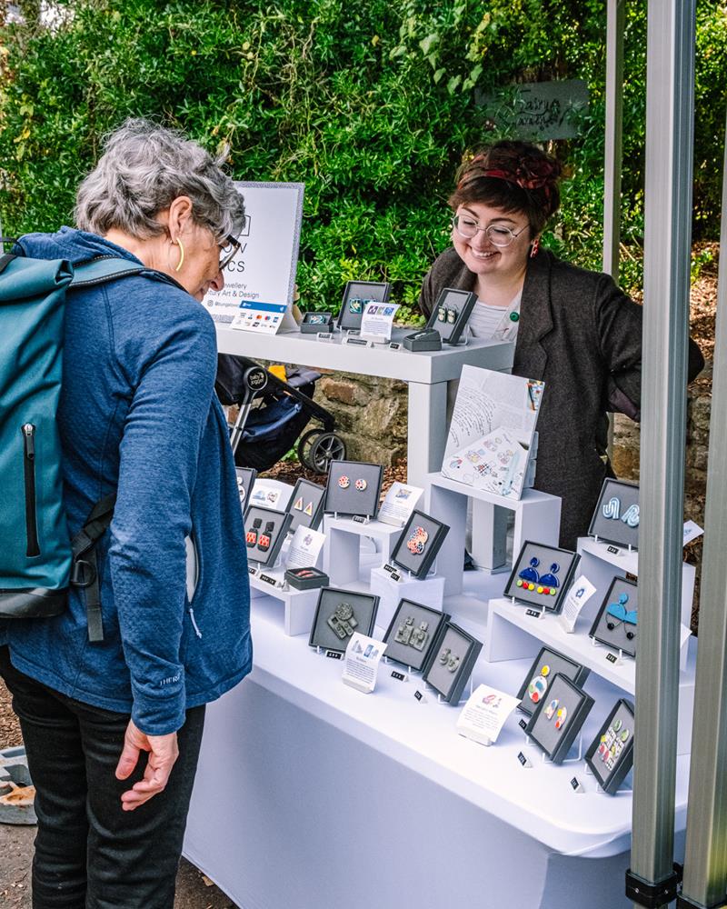 customer looking at Bungalow Ceramics brightly coloured jewellery at craft stall