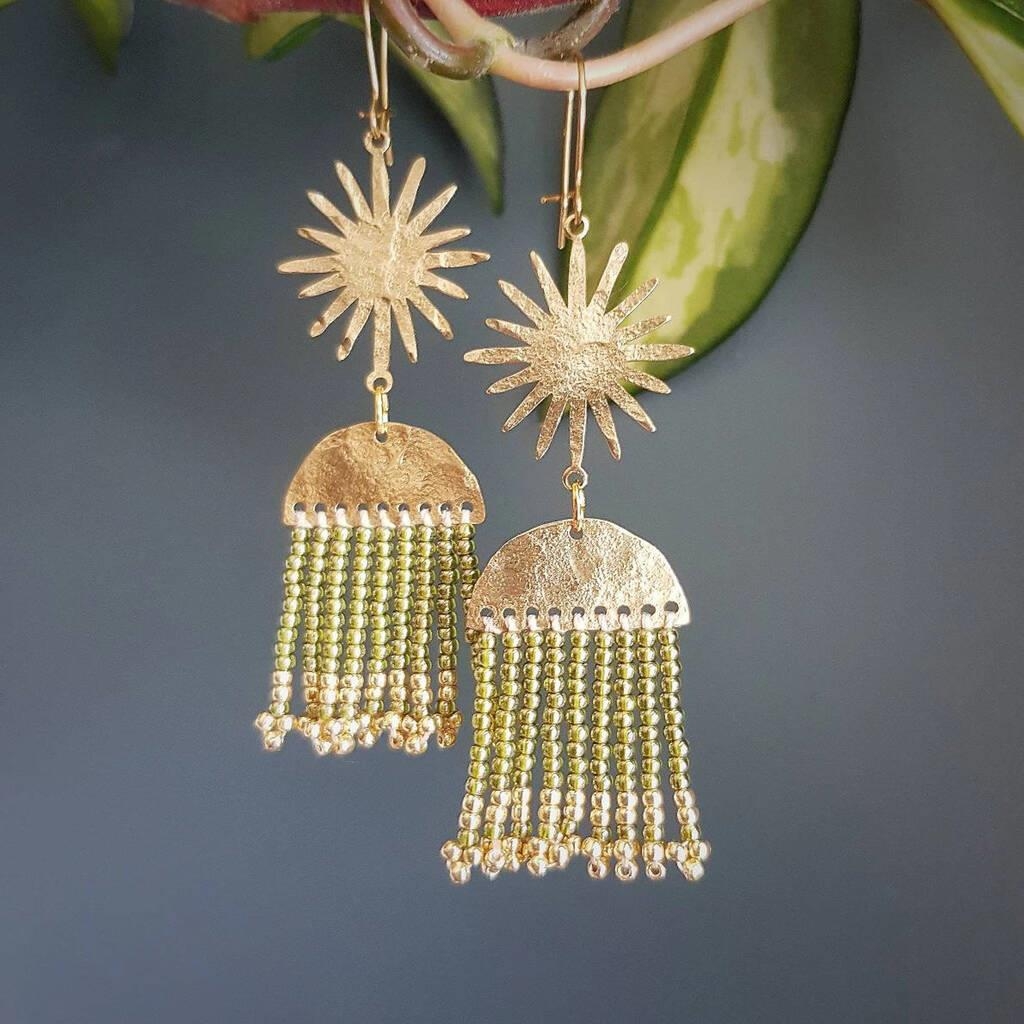Hand beaten delicate brass and bead earrings by Nic Danning, 'celestial heraicarus'' a semicircle with fringes of beads in light green and gold, with sun above.