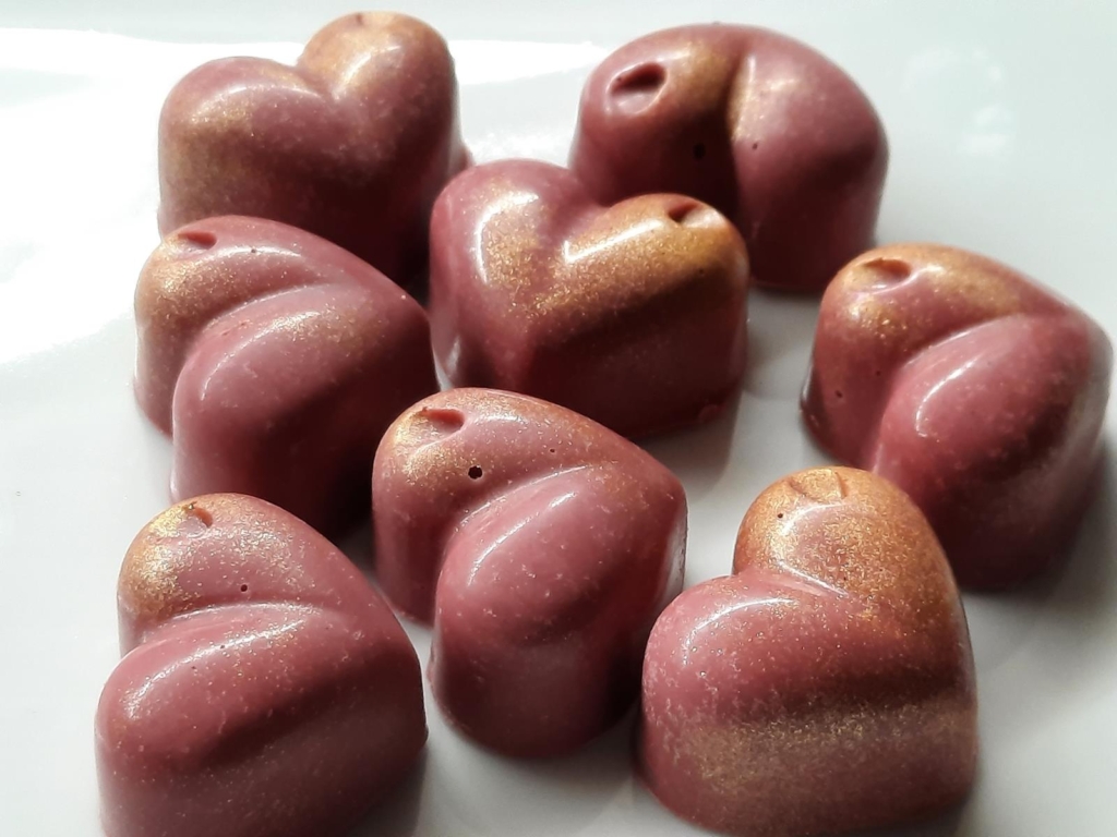 Eight heart-shaped chocolates, with a pink-gold glaze, by Vicolo Sei.